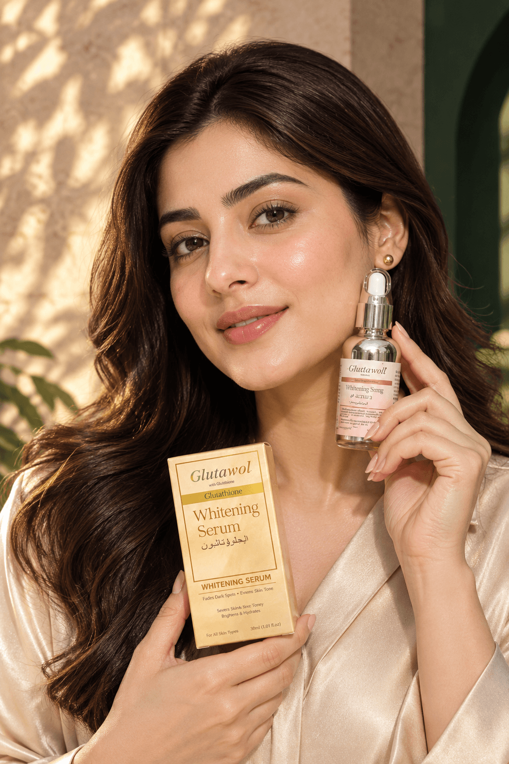 South Asian woman model with radiant glowing glass skin holding Glutawol amber dropper serum